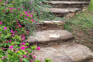 Inspiration for a mid-sized traditional full sun and drought-tolerant backyard stone retaining wall landscape in Atlanta for fall.