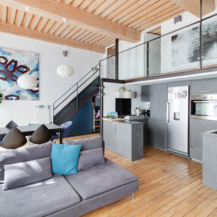 Inspiration pour une cuisine design en U avec un placard à porte plane, des portes de placard grises, un électroménager en acier inoxydable, un sol en bois brun, une péninsule, un sol marron, un plan de travail gris et un plafond en bois.