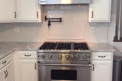 Inspiration for a large transitional l-shaped dark wood floor eat-in kitchen remodel in Atlanta with recessed-panel cabinets, white cabinets, marble countertops, white backsplash, subway tile backsplash and stainless steel appliances