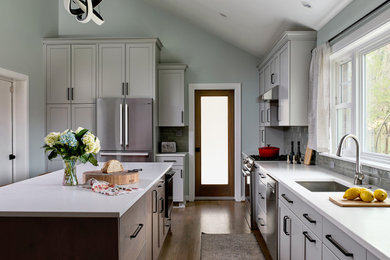 Transitional l-shaped medium tone wood floor eat-in kitchen photo in DC Metro with subway tile backsplash, stainless steel appliances and an island