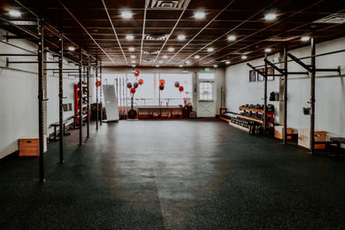 Inspiration for an industrial black floor home gym remodel in Philadelphia with white walls