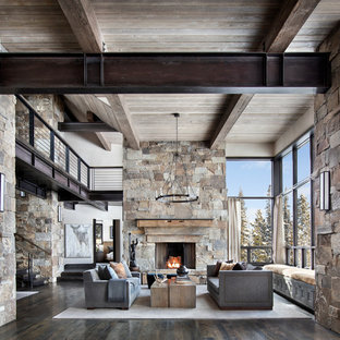 Inredning av ett modernt stort allrum med öppen planlösning, med beige väggar, mörkt trägolv, en standard öppen spis, en spiselkrans i sten, brunt golv och ett finrum