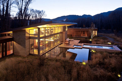 Large trendy brown two-story wood house exterior photo in Other with a shed roof and a metal roof