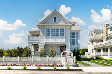 Inspiration for a coastal white three-story shingle house exterior remodel in Philadelphia with a hip roof and a shingle roof