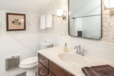 Photo of a medium sized classic bathroom in Other with shaker cabinets, medium wood cabinets, an alcove bath, an alcove shower, a two-piece toilet, white tiles, metro tiles, beige walls, porcelain flooring, an integrated sink, solid surface worktops, grey floors, a shower curtain, white worktops, a single sink and a built in vanity unit.