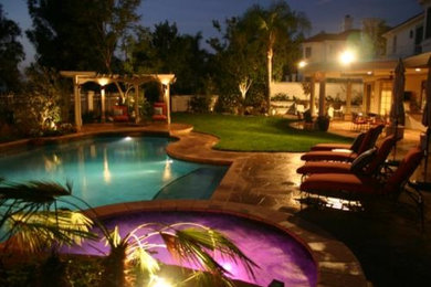Hot tub - large contemporary backyard stone and custom-shaped aboveground hot tub idea in Los Angeles