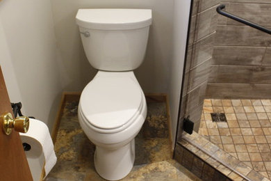 Small southwest 3/4 vinyl floor corner shower photo in Other with raised-panel cabinets, light wood cabinets, a two-piece toilet, a drop-in sink and tile countertops