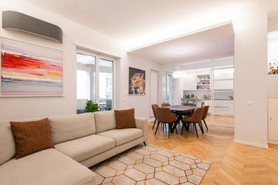 Idee per un soggiorno contemporaneo con pareti bianche e parquet chiaro