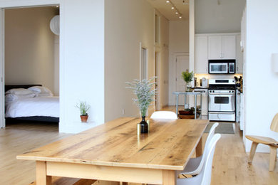 Inspiration for a large modern open plan dining in New York with white walls and light hardwood floors.