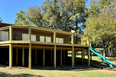 Inspiration for a mid-sized rustic backyard ground level wood railing deck remodel in Little Rock with no cover