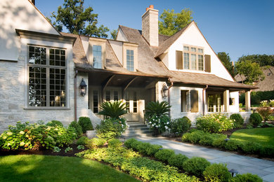 Eclectic beige two-story stone exterior home photo in Chicago with a hip roof