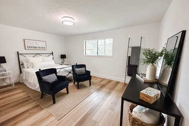 Modelo de dormitorio principal de estilo de casa de campo grande con paredes blancas, suelo vinílico y suelo beige