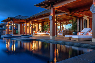 Photo of an expansive tropical backyard patio in Hawaii with a fire feature, tile and a roof extension.