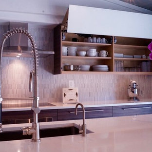 Imagen de cocina en L, contemporánea, grande, abierta, con fregadero bajoencimera, armarios con paneles lisos, puertas de armario de madera en tonos medios, encimera de cuarzo compacto, salpicadero verde, salpicadero de azulejos de cerámica, electrodomésticos de acero inoxidable, suelo de pizarra, una isla, suelo gris y encimeras blancas