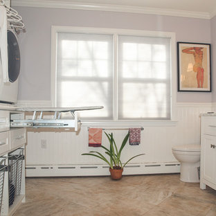 Design ideas for a medium sized contemporary u-shaped utility room in New York with a submerged sink, shaker cabinets, white cabinets, marble worktops, purple walls, a stacked washer and dryer and porcelain flooring.