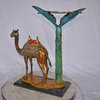 Camel Standing Under A Palm Tree Bronze Statue - Size: 20"L x 29"W x 25"H.