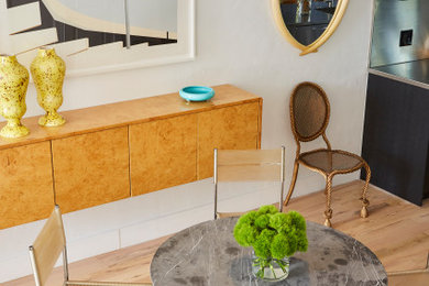 Example of a mid-sized eclectic light wood floor kitchen/dining room combo design in New York with white walls