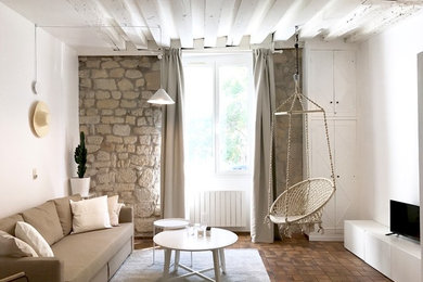 Idées déco pour un salon méditerranéen avec un mur blanc et tomettes au sol.