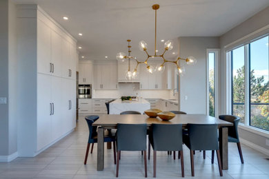 Inspiration for a large modern l-shaped ceramic tile and gray floor eat-in kitchen remodel in New York with an undermount sink, flat-panel cabinets, white cabinets, quartzite countertops, white backsplash, ceramic backsplash, stainless steel appliances, an island and white countertops