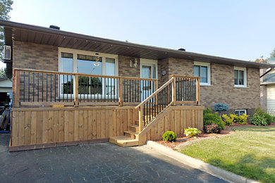 Mid-sized transitional side yard ground level wood railing deck photo in Other