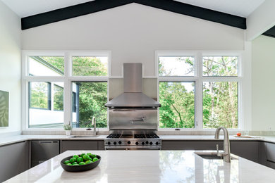 Inspiration for a mid-sized contemporary u-shaped porcelain tile, gray floor and exposed beam eat-in kitchen remodel in Cincinnati with an undermount sink, flat-panel cabinets, gray cabinets, quartzite countertops, white backsplash, window backsplash, stainless steel appliances, an island and white countertops