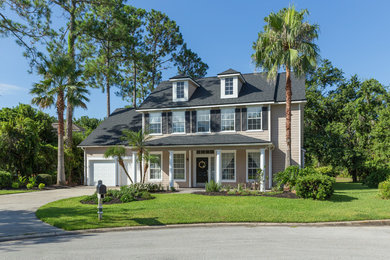 Traditional beige two-story wood house exterior idea in Jacksonville with a shingle roof
