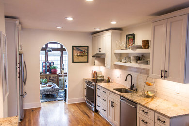 Inspiration for a transitional medium tone wood floor kitchen remodel in Other with granite countertops, subway tile backsplash and stainless steel appliances