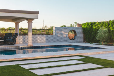 Imagen de piscina tradicional renovada rectangular en patio trasero con paisajismo de piscina y adoquines de piedra natural