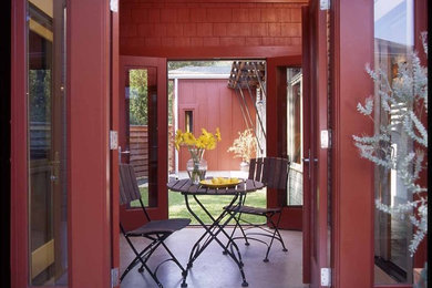 Mid-sized eclectic courtyard concrete patio photo in Austin with a roof extension