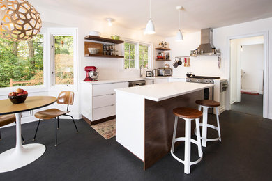 Inspiration for a 1960s u-shaped eat-in kitchen remodel in Indianapolis with a single-bowl sink, dark wood cabinets, quartz countertops, white backsplash, subway tile backsplash, stainless steel appliances and an island