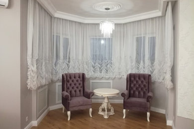 Modelo de salón tradicional grande con paredes púrpuras, suelo laminado, televisor colgado en la pared y suelo beige