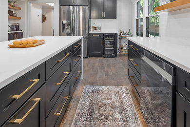 Example of a large transitional u-shaped kitchen pantry design in Charlotte with an undermount sink, recessed-panel cabinets, subway tile backsplash, stainless steel appliances, an island and white countertops