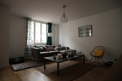This is an example of a medium sized scandi open plan living room in Lyon with white walls, light hardwood flooring, no fireplace and brown floors.