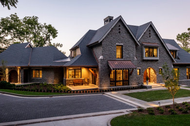 Inspiration for a timeless gray three-story stone exterior home remodel in Nashville with a shingle roof and a black roof