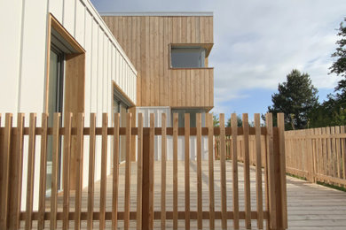 Cette photo montre une façade de maison blanche tendance en bardage à clin de taille moyenne et à un étage avec un revêtement mixte, un toit en appentis, un toit en métal et un toit blanc.