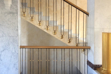 На фото: лестница в классическом стиле с мраморными ступенями и металлическими перилами с