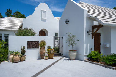 Inspiration for a large coastal white one-story stucco house exterior remodel with a mixed material roof and a white roof
