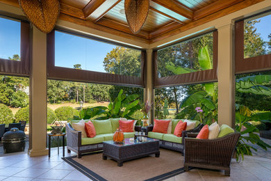 Inspiration for a large tropical concrete paver screened-in back porch remodel in Raleigh with a roof extension