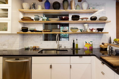 Example of a mid-sized transitional u-shaped dark wood floor open concept kitchen design in Portland with an undermount sink, flat-panel cabinets, white cabinets, wood countertops, white backsplash, stone tile backsplash, stainless steel appliances and a peninsula