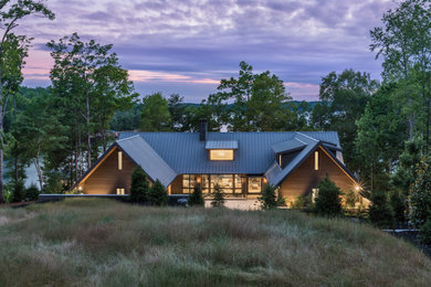 Mid-sized contemporary brown three-story wood and clapboard exterior home idea with a metal roof and a brown roof