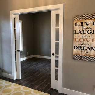 Photo of a medium sized modern study in Other with grey walls, vinyl flooring, a freestanding desk and brown floors.
