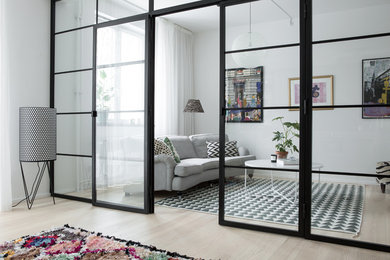 Imagen de sala de estar bohemia de tamaño medio con paredes blancas y suelo de madera clara