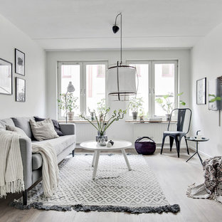 Idéer för mellanstora minimalistiska avskilda allrum, med vita väggar, ljust trägolv och beiget golv
