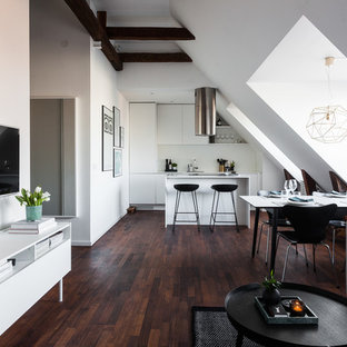 Imagen de sala de estar abierta, nórdica, de tamaño medio, sin chimenea, con paredes beige, suelo de madera oscura y televisor colgado en la pared