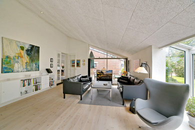 Ejemplo de sala de estar cerrada nórdica sin chimenea y televisor con paredes blancas, suelo de madera clara y suelo beige