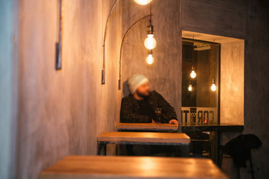 Immagine di un piccolo angolo bar industriale con ante in legno chiaro, pavimento in gres porcellanato e pavimento verde