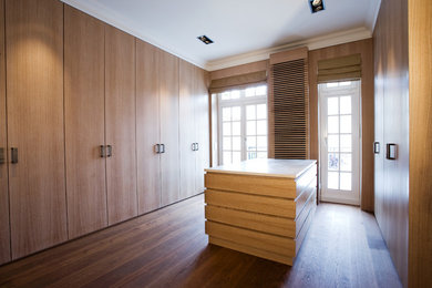 Mittelgroßer, Neutraler Moderner Begehbarer Kleiderschrank mit hellbraunen Holzschränken und dunklem Holzboden in Hamburg