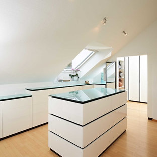 Mittelgroßes, Neutrales Modernes Ankleidezimmer mit Ankleidebereich, flächenbündigen Schrankfronten, weißen Schränken, braunem Holzboden und braunem Boden in Stuttgart