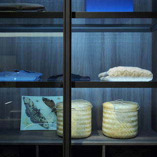 Idee per un'ampia cabina armadio unisex contemporanea con ante di vetro, ante bianche, parquet scuro e pavimento marrone