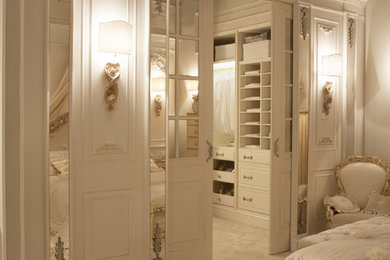 Modelo de armario vestidor unisex tradicional grande con armarios con paneles con relieve, puertas de armario blancas, moqueta y suelo beige